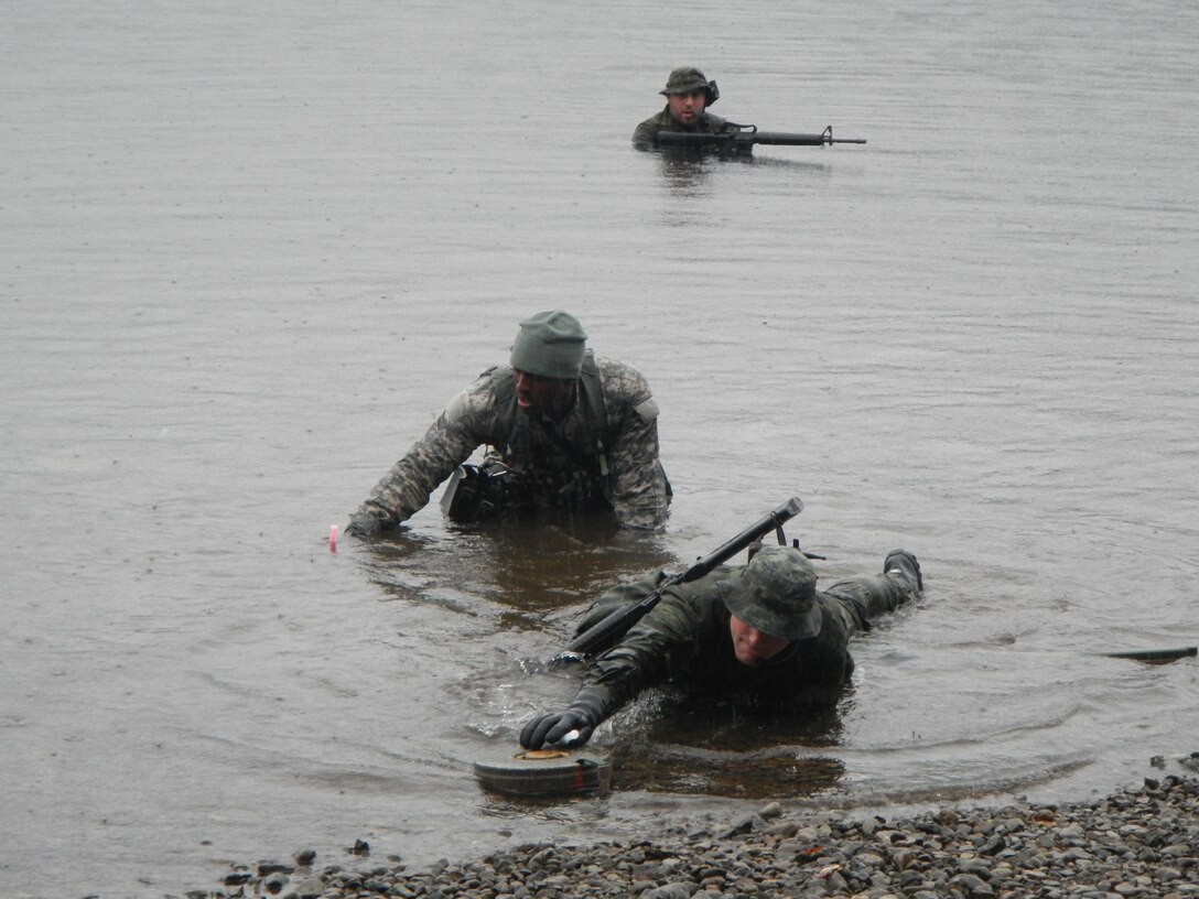 U.S. and Canadian Army divers clear and mark a lane through a beachfront anti-tank minefield during a coalition training exercise at Comox Lake, British Columbia, Canada, Feb. 15, 2016. The U.S. Soldiers trained with coalition partners to exchange better tactics and practices for security swims. (Canadian Army courtesy photo)