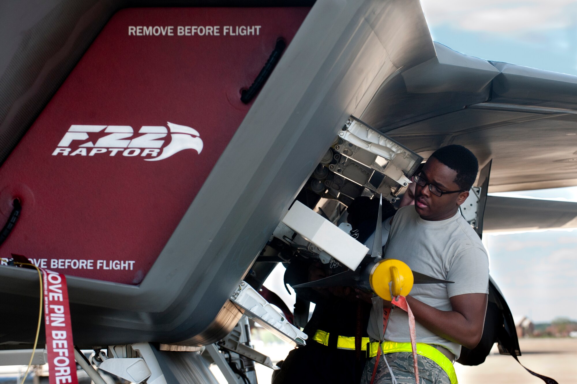 U.S. Air Force Airman 1st Class Brian Stewart, a weapons load crew member with the 27th Aircraft Maintenance Unit, and his team load the second AIM-9 missile onto an F-22 Raptor during the Second Quarter Weapons Load competition at Langley Air Force Base, Va., April 8, 2016. The quarterly competition tests load crew teams’ knowledge, professionalism and ability to accurately and quickly load weapons onto an aircraft. (U.S. Air Force photo by Senior Airman R. Alex Durbin/Released)