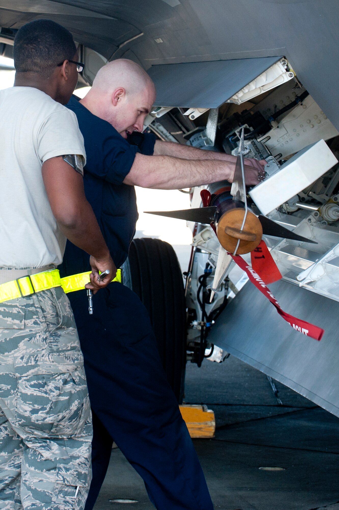 U.S. Air Force Staff Sgt. Aaron Cridge and Airman 1st Class Brian Stewart, weapons load crew members with the 27th Aircraft Maintenance Unit, load an AIM-9 missile onto an F-22 Raptor during the Second Quarter Weapons Load competition at Langley Air Force Base, Va., April 8, 2016. Weapons load crews work in three-person teams to inspect and load munitions onto aircraft in a timely and accurate manner. (U.S. Air Force photo by Senior Airman R. Alex Durbin/Released)