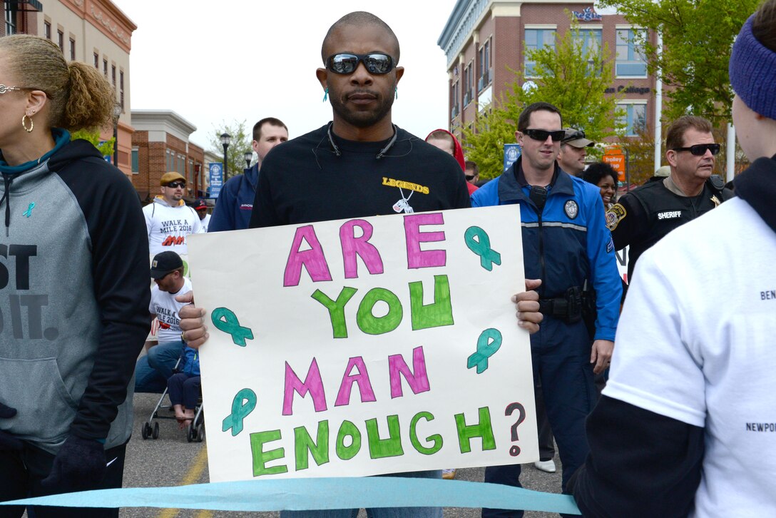 A participant in the “Walk a Mile in Her Shoes” event holds a sign to display his support for sexual assault awareness in Hampton, Va., April 9, 2016. Men wore women’s high heels during the mile-long walk to symbolize women’s oppression. (U.S. Air Force photo by Airman 1st Class Kaylee Dubois)