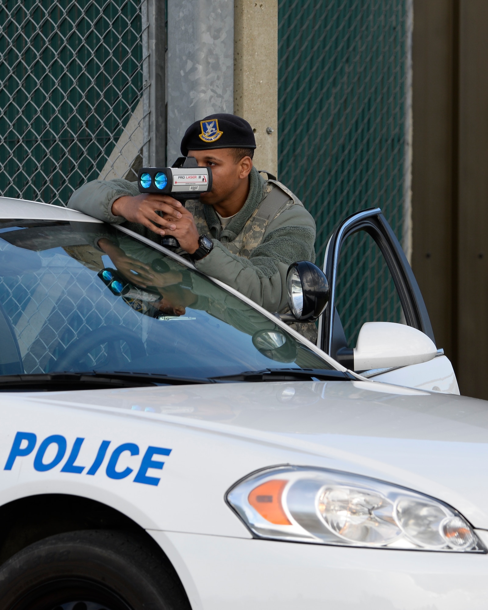 U.S. Air Force Senior Airman Ricardo Woods, 100th Security Forces Squadron defender, aims a radar gun towards oncoming traffic March 29, 2016, on RAF Mildenhall, England. The 100th SFS members routinely monitor traffic on the installation to ensure the safety of its populace and assets. (U.S. Air Force photo by Senior Airman Victoria H. Taylor/Released)