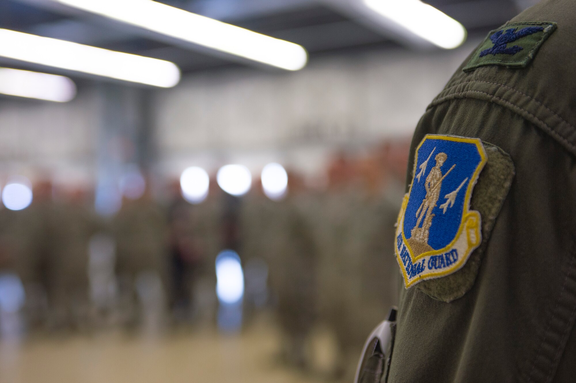 A U.S. Air National Guard patch remains on a flightsuit during a commander’s call at Leeuwarden Air Base, Netherlands, April 12, 2016. Approximately 350 Airmen from Barnes Air National Guard Base, Mass., Fresno Air National Guard Base, Calif., and Spangdahlem Air Base, Germany, will deploy for six months to conduct training alongside NATO allies to strengthen interoperability and to demonstrate U.S. commitment to the security and stability of Europe. (U.S. Air Force photo by Staff Sgt. Joe W. McFadden/Released)