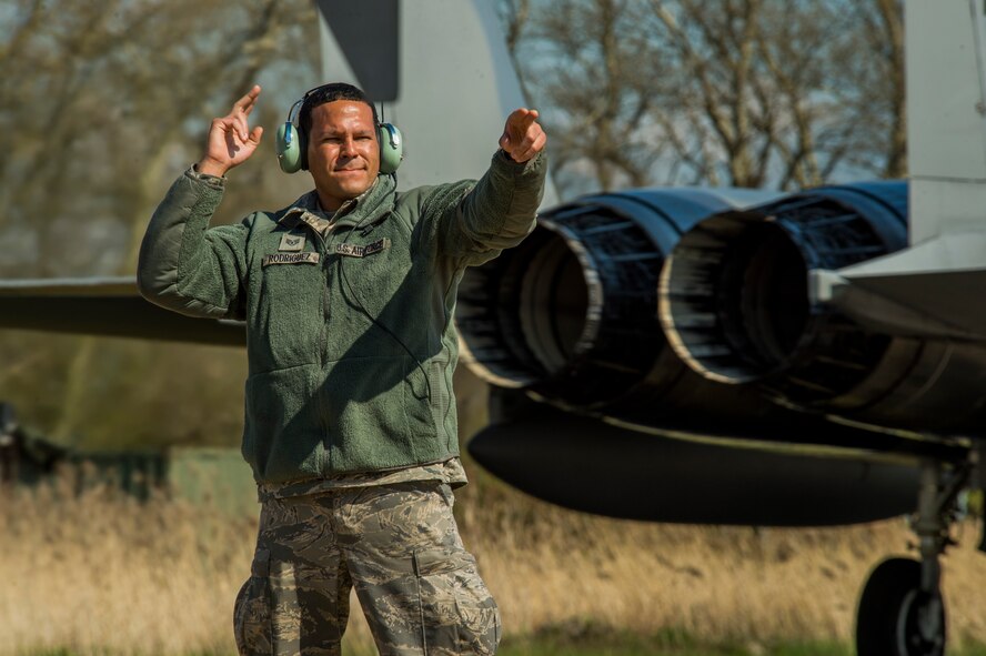 U.S. Air Force and Massachusetts Air National Guard Staff Sgt. Juan Rodriguez, a 104th Aircraft Maintenance Squadron crew chief and Springfield, Mass., native, waves a U.S. Air Force F-15C Eagle fighter aircraft assigned to the 131st Expeditionary Fighter Squadron on the flightline during a theater security package deployment at Leeuwarden Air Base, Netherlands, April 12, 2016. The U.S. Air Force and other services have increased their rotational presence in Europe to reassure allies and partner nations about the U.S.’s commitment to European security and stability. (U.S. Air Force photo by Staff Sgt. Joe W. McFadden/Released)