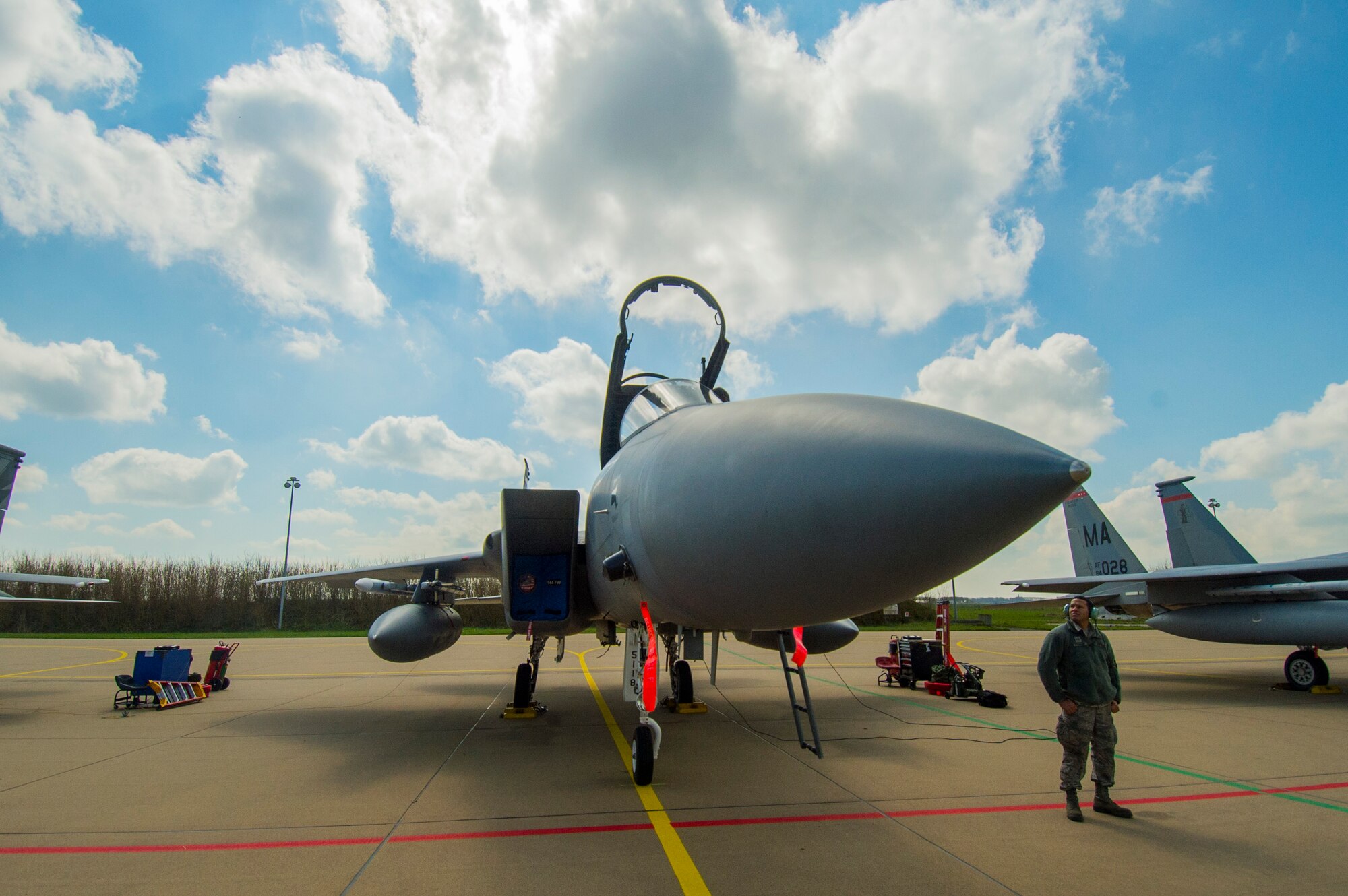 U.S. Air Force and Massachusetts Air National Guard Staff Sgt. Juan Rodriguez, a 104th Aircraft Maintenance Squadron crew chief and Springfield, Mass., native, looks up at a U.S. Air Force F-15C Eagle fighter aircraft assigned to the 131st Expeditionary Fighter Squadron on the flightline during a theater security package deployment at Leeuwarden Air Base, Netherlands, April 12, 2016. The F-15s will conduct training alongside NATO allies to strengthen interoperability and to demonstrate U.S. commitment to the security and stability of Europe. The F-15s from the Massachusetts and California Air National Guard are deployed to Europe as part of the TSP. (U.S. Air Force photo by Staff Sgt. Joe W. McFadden/Released)