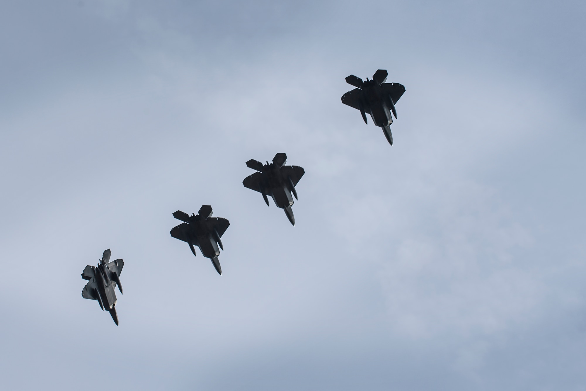 A formation of F-22 Raptors from the 95th Fighter Squadron prepare to land at Royal Air Force Lakenheath, England, April 12, 2016. The training allows the perfect opportunity for the advanced aircraft to train alongside other U.S. Air Force aircraft, joint partners and NATO allies. (U.S. Air Force photo/Airman 1st Class Erin R. Babis)