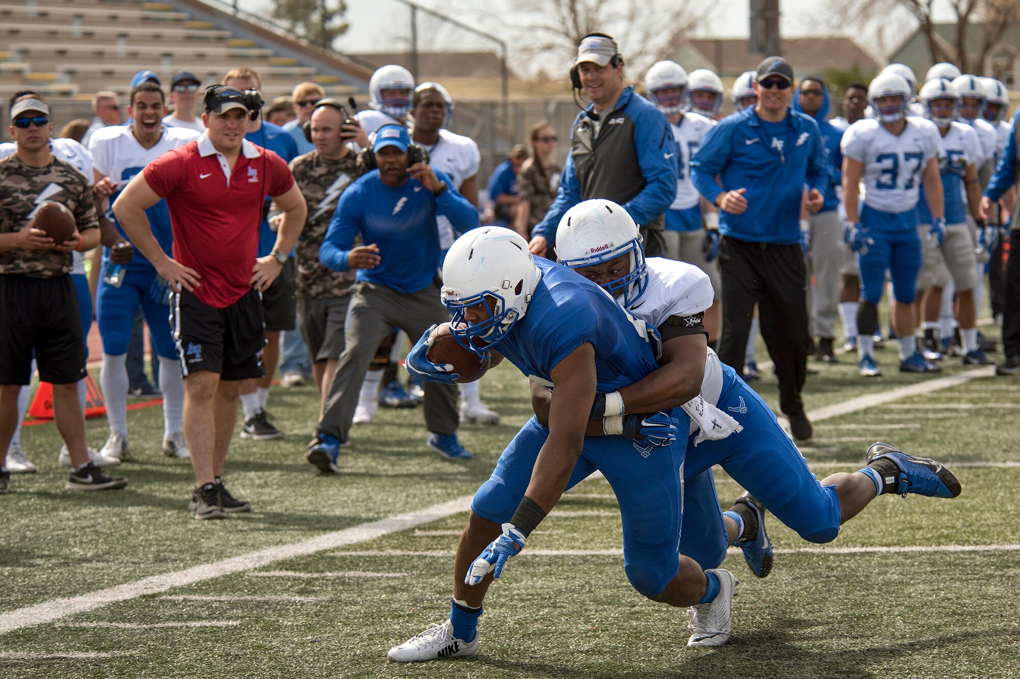 COLORADO SPRINGS, Colo. – Coaches and United States Air Force Academy Falcons Football players cheer as they witness a tackle during a spring game practice April 9, 2016 at Falcon-Fort Carson High School. The academy has produced over 200 individual national champions and 680 individual athletes have achieved athletic All-American status.  (U.S. Air Force Photo by Craig Denton)
