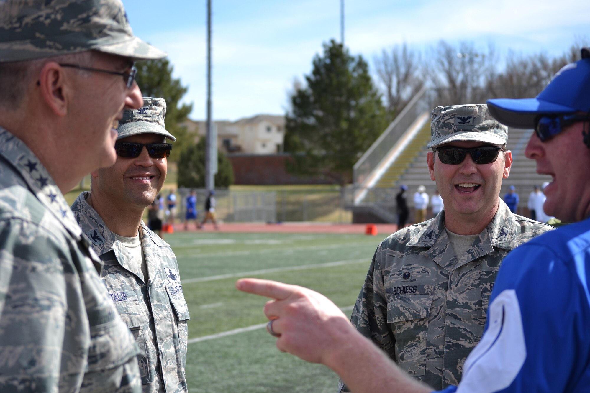 COLORADO SPRINGS, Colo. - Gen. John Hyten, commander Air Force Space Command; Col. Douglas Schiess, 21st Space Wing commander, and Col. Anthony Mastalir, 50th Space Wing vice commander, discuss strategy with U.S. Air Force Academy offensive coordinator Mike Thiessen before the start of the Blue-Silver game at Fountain-Fort Carson High School, Saturday, April 9, 2016. The three commanders served as honorary coaches for the offense while command staff from Fort Carson helped lead the defense during the annual intrasquad scrimmage. (U.S. Air Force photo/Brian Hagberg)