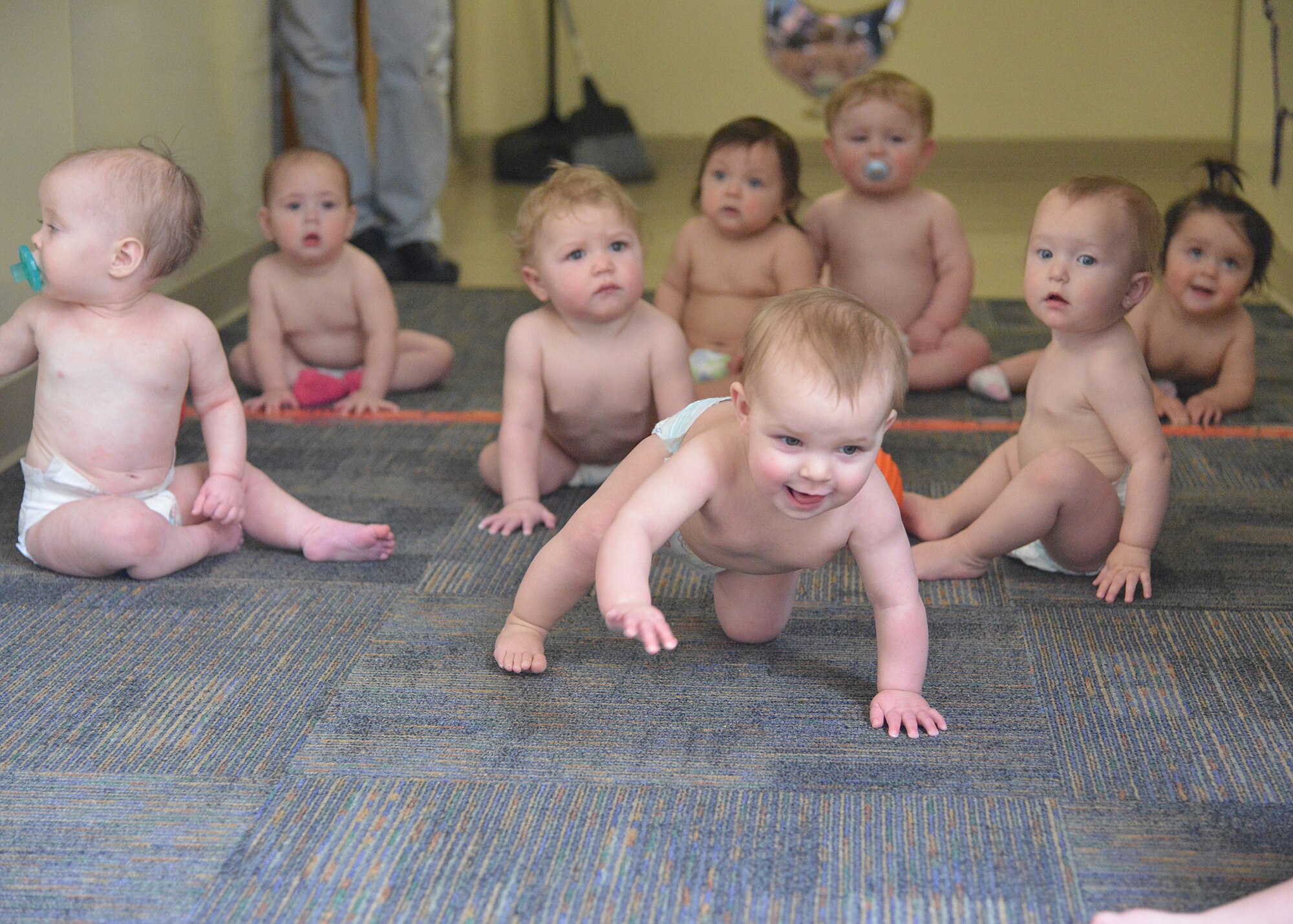 Babies at the Gibson Child Development Center try to figure out the “Diaper Derby” on April 7. As part of the observance of the Month of the Military Child in April, the babies were encouraged to crawl down the hall toward their parents, center staff members or toys. The center has several other special events in honor of the month’s designation. (Photo by Todd Berenger)