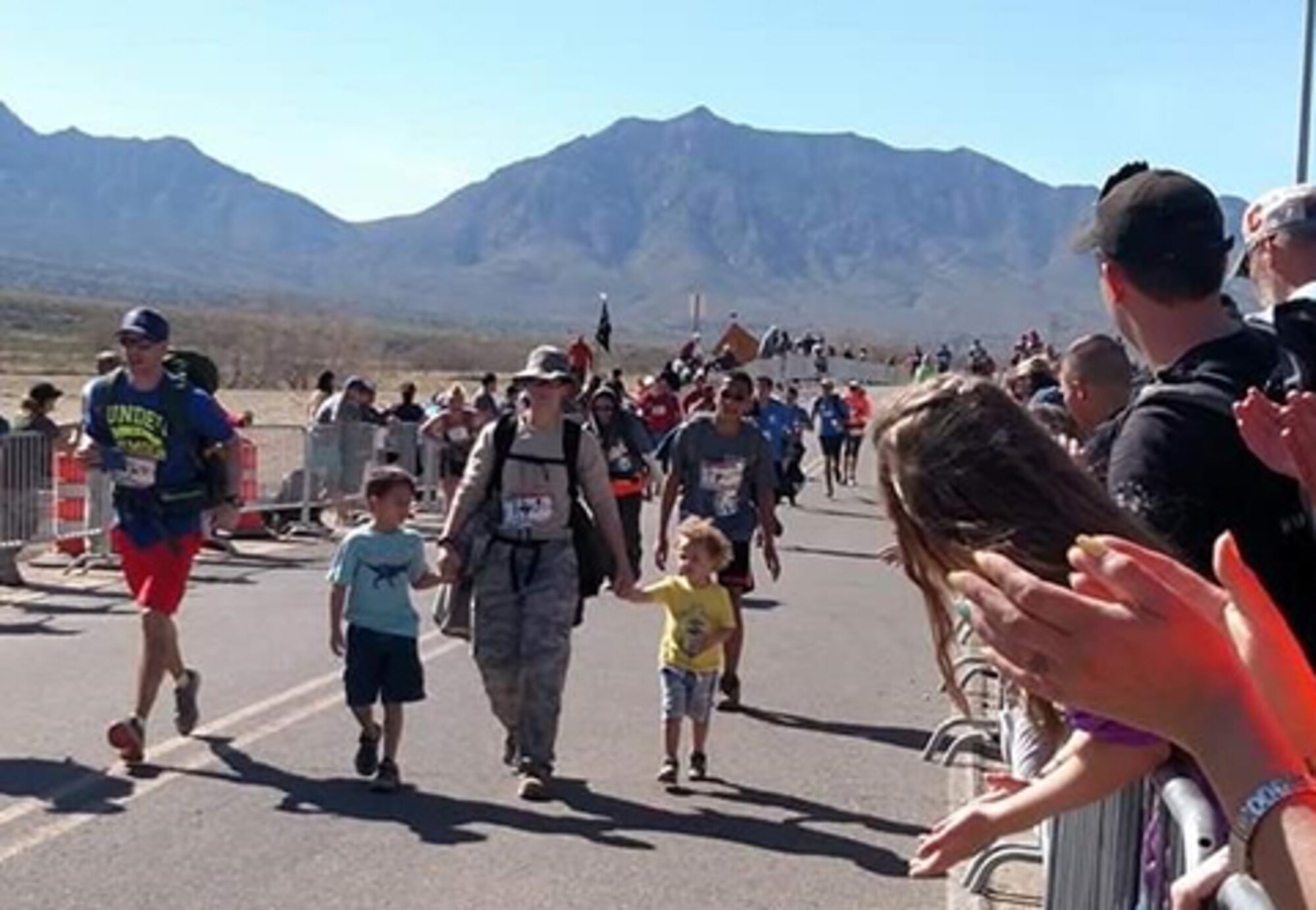 Tech. Sgt. Julia Getter, 53rd Test Support Squadron weapons evaluation group logistics manager, crosses the finish line of the Bataan Memorial Death March with her kids. This was Getter’s fifth time taking part in the grueling 26.2-mile march.  (Courtesy photo)