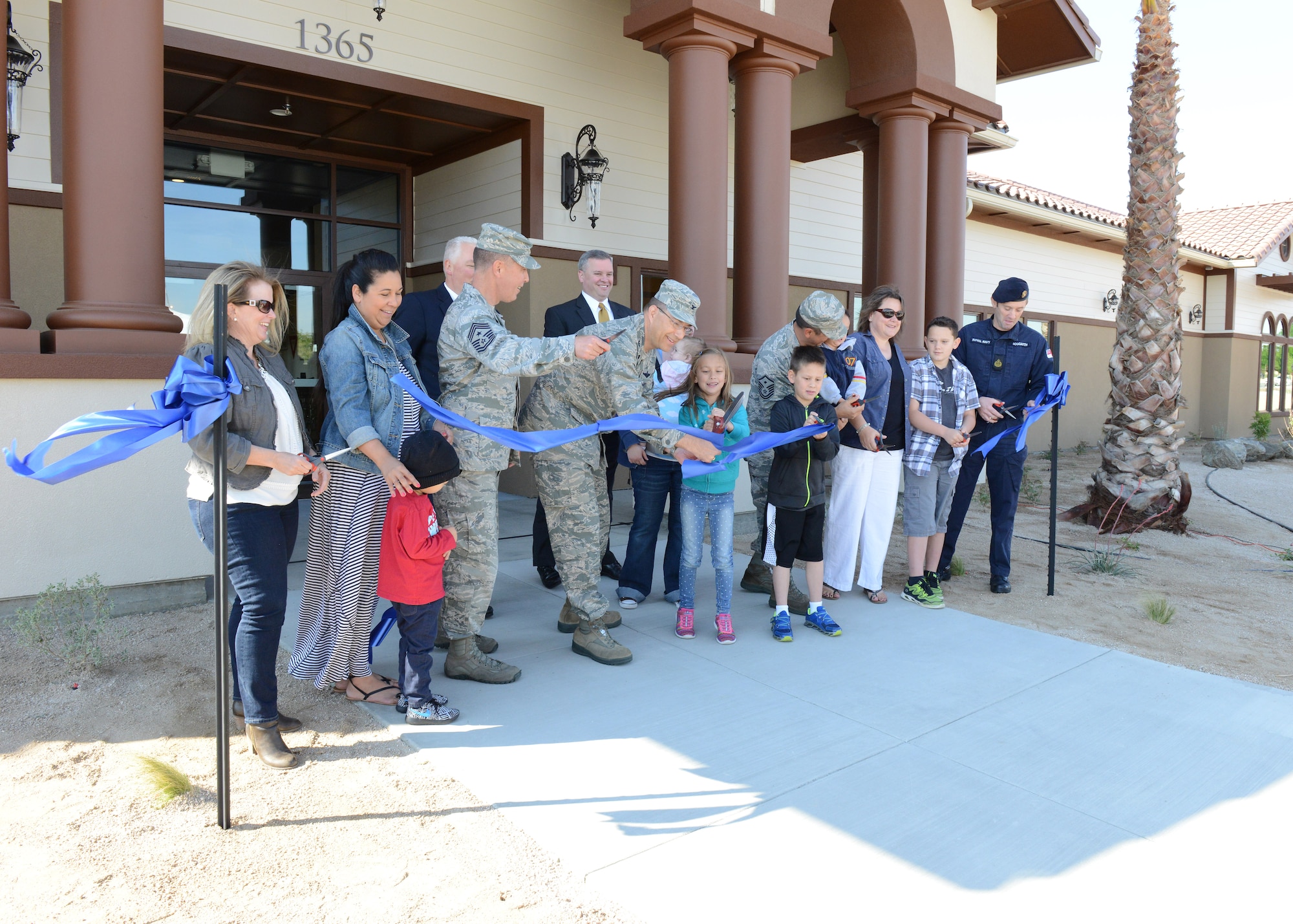 Col. David Radomski (center), 412th Test Wing vice commander, joins base residents and Corvias Military Living representatives in cutting the ceremonial ribbon officially opening up the Mojave Sky Community Center April 13. (U.S. Air Force photo by Kenji Thuloweit)