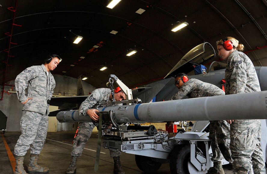 Weapons load crew members from the 67th Aircraft Maintenance Unit transport an AIM-120 advanced medium-range air-to-air missile to an MJ-1C lift truck while being inspected by loading standardization crews during weapons load training session April 13, 2016, at Kadena Air Base, Japan. The 18th Maintenance Group conducts weapons load training monthly designed to exercise teamwork skills, proficiency and core combat competency for real-world operations. (U.S. Air Force photo by Naoto Anazawa)
