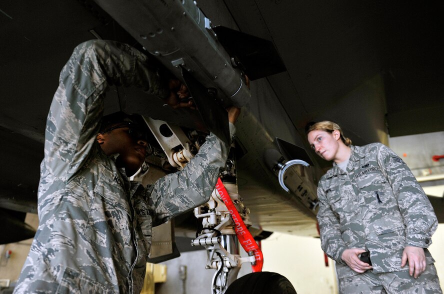 U.S. Air Force Airman 1st Class Jelani McCray, 67th Aircraft Maintenance Unit weapons load crew member, secures an AIM-120 advanced medium-range air-to-air missile while being inspected by Senior Airman Sarah Owen, 18th Maintenance Group loading standardization crew, during a weapons load training session April 13, 2016, at Kadena Air Base, Japan. The 18 MXG provides training for more than 2,400 aircraft maintainers and munitions handlers. The group also provides maintenance support and facilities for all other forces assigned to or transiting Kadena. (U.S. Air Force photo by Naoto Anazawa)