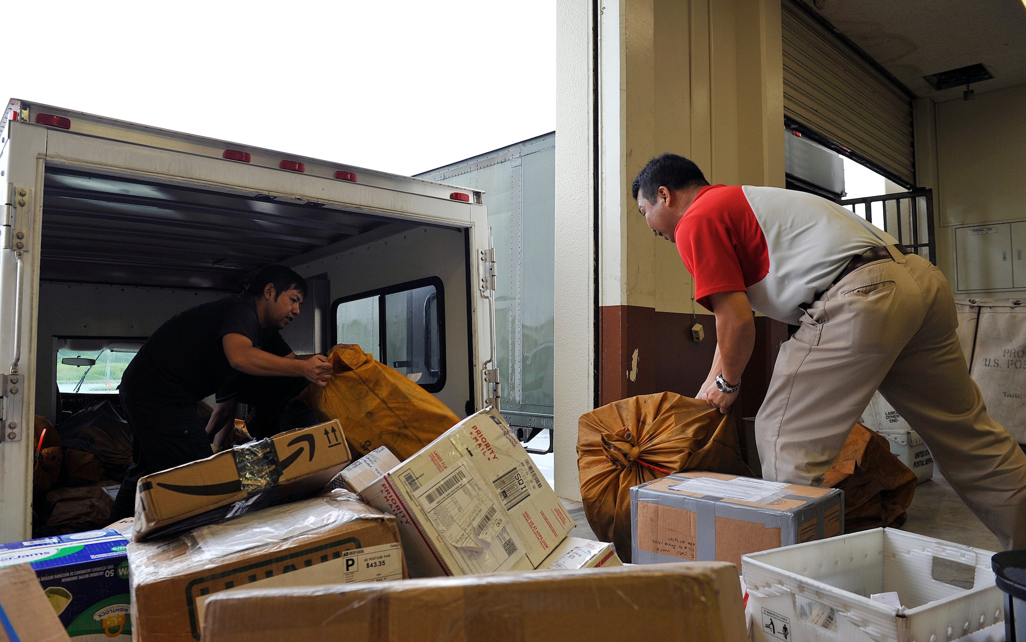 Japanese employees from the Kadena Post Office unload packages from a truck April 12, 2016, at Kadena Air Base, Japan. The post office typically processes approximately 500 packages a day during non-holiday seasons. (U.S. Air Force photo by Naoto Anazawa)

