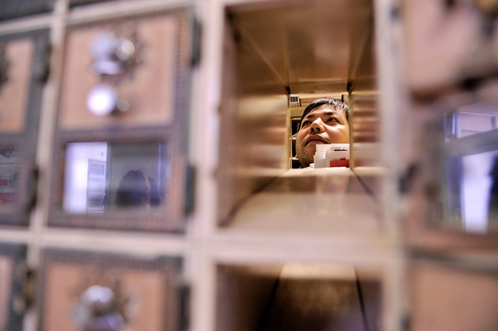 Masahiro Iha, 18th Communications Squadron mail sorting clerk, processes mail and package pick-up notices at the Kadena Air Base Post Office April 12, 2016, at Kadena Air Base, Japan. The mission of the post office is to provide both personal and official mail to the service members and their families here on the island. (U.S. Air Force photo by Naoto Anazawa)
