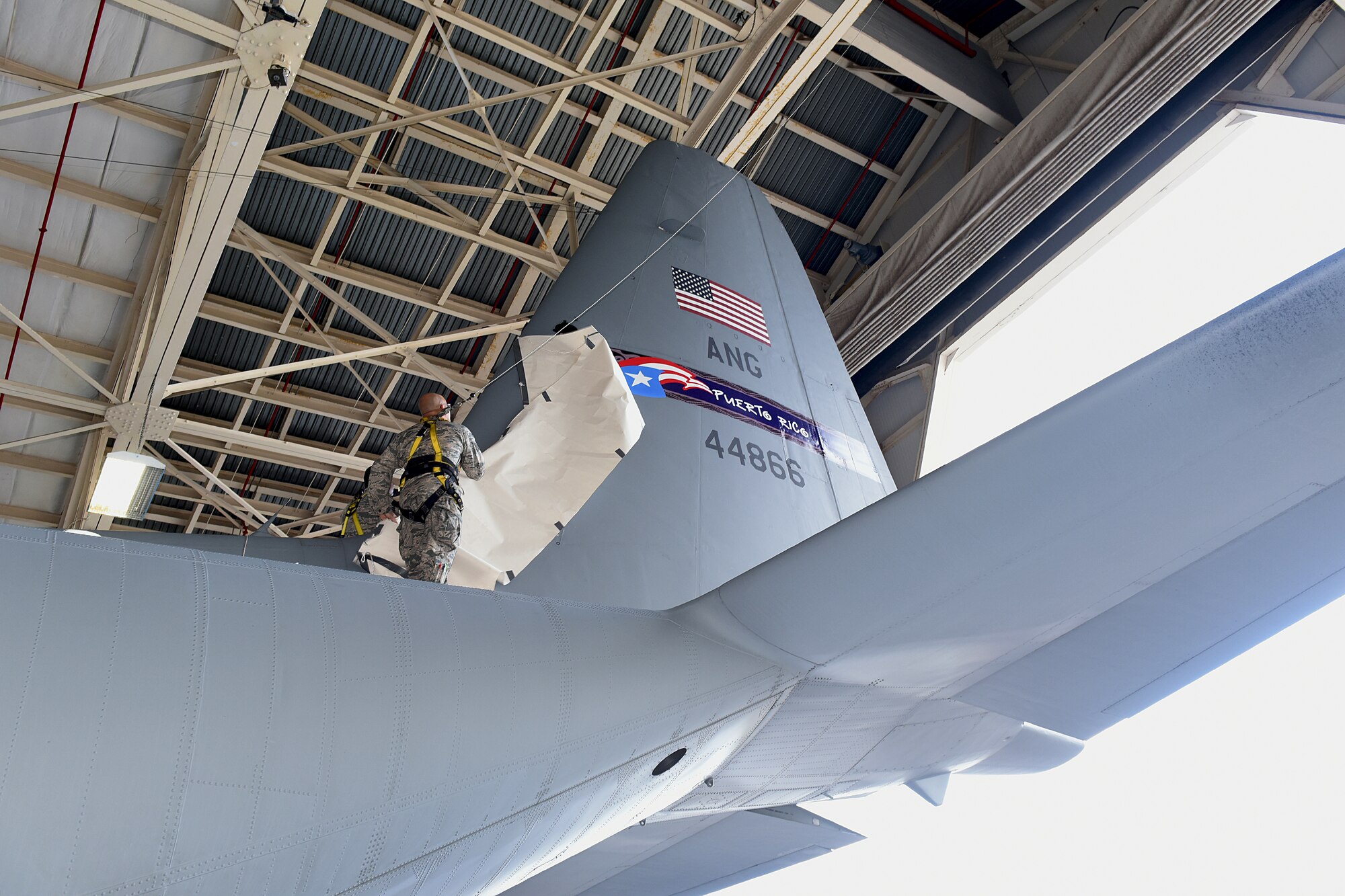 U.S. Air Force airmen unveils the winning tail flash for 156th Airlift Wing, Muñiz Air National Guard Base, Carolina, Puerto Rico, during the WC-130 Tail Flash Unveiling Ceremony in Hangar 1, March 6, 2016. Winning design was designed by Staff Sgt. Luis A. Morales, aircrew flight equipment of the 156th Operation Squadron. (U.S. Air National Guard photo by Tech. Sgt. Efrain Sanchez)