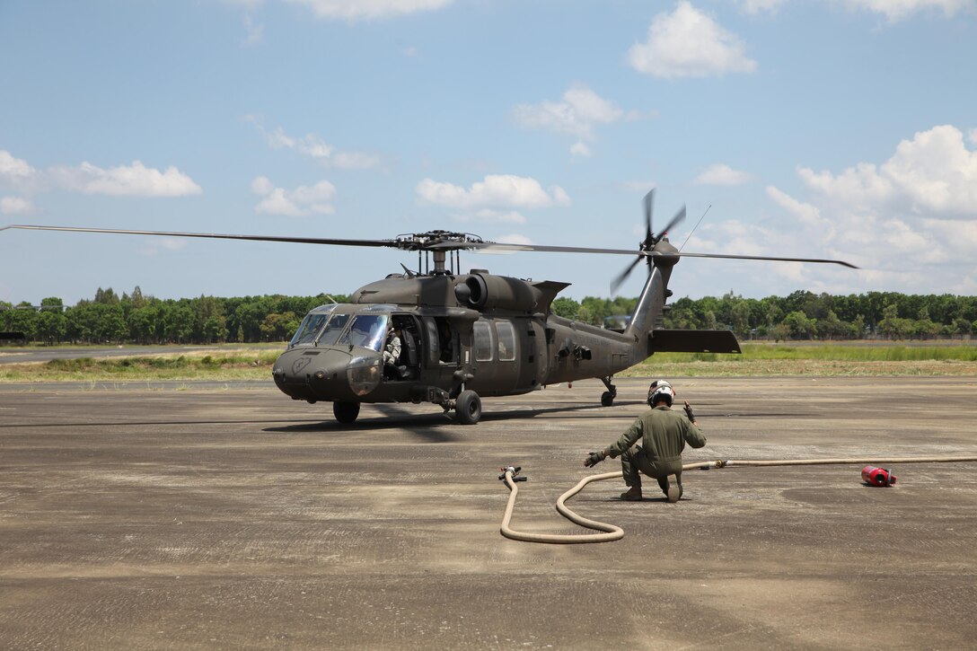 U.S. Marine Cpl. Christos Onoufriadis guides a U.S. Army UH-60 Black Hawk towards an aerial delivery ground refueling station during Balikatan 16, in San Fernando, Philippines, April 12, 2016. Onoufriadis is from Redding, California and a MV-22B Osprey crew chief for Marine Medium Tilt-rotor Squadron 262, Marine Aircraft Group 36, 1st Marine Aircraft Wing, III Marine Expeditionary Force. After establishing the ADGR, the Marines of VMM-262 refueled multiple U.S. Army aircrafts from Bravo 3-25, Aviation Regiment via the MV-22B Osprey.