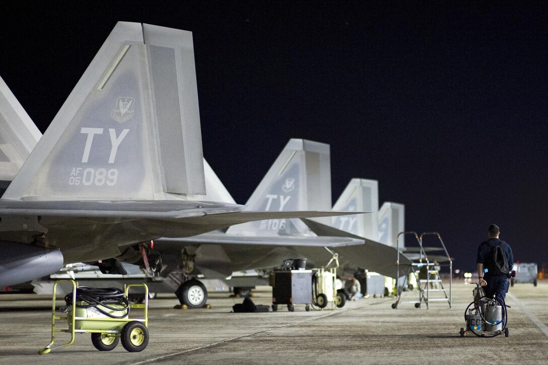 Air Force Staff Sgt. Dustin Haley pulls an oil cart down the flightline before F-22 Raptor aircraft take off at Tyndall Air Force Base, Fla., April 11, 2016. Haley is a crew chief assigned to the 95th Aircraft Maintenance Unit. Air Force photo by Senior Airman Alex Fox Echols III