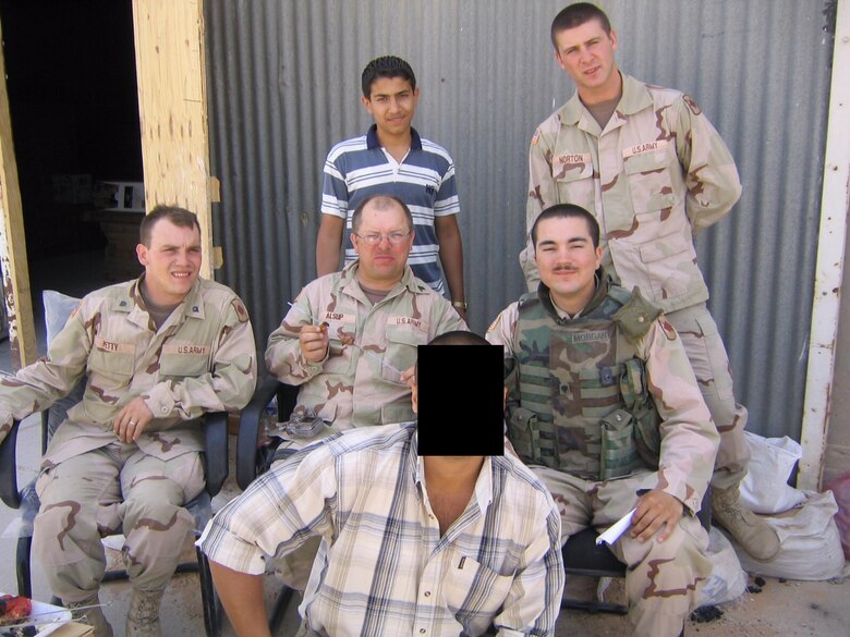 CAMP COOK, TAJI, IRAQ – (Center rear) U.S. Marine Corps 2nd Lt. Ahmed Khalil, then the operations manager for Al-Andalus Company, stands with soldiers from 39th Infantry Brigade Combat Team after working on supply and install completion for 9600 bedroom sets located in Camp Cooke Taji, Iraq in the mid-2000’s. (Courtesy photo by 2nd. Lt. Ahmed Khalil/Released)