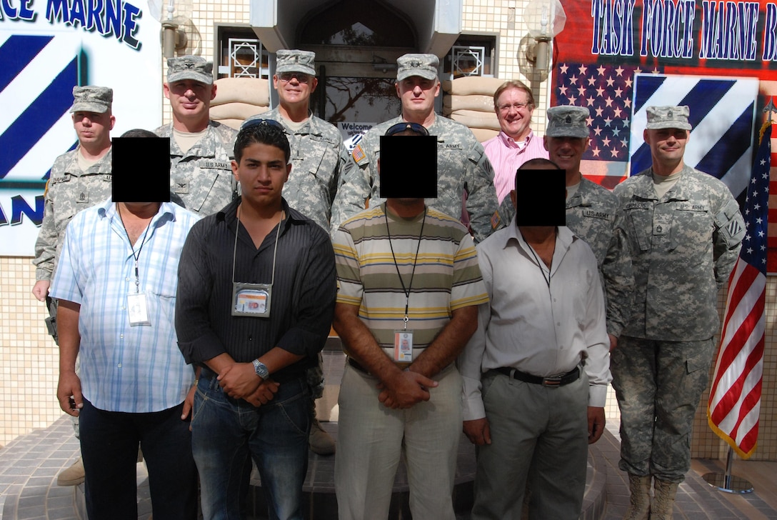 CAMP VICTORY, IRAQ – (Center Front) U.S. Marine Corps 2nd Lt. Ahmed Khalil, then the operations manager for Al-Andalus Company stands with those involved in the completion of the 3rd Infantry Division Band Hall located at Camp Victory, Iraq. Khalil’s work with U.S. troops would shape his desire to become a United States Marine a few years later. (Courtesy photo by 2nd. Lt. Ahmed Khalil/Released)