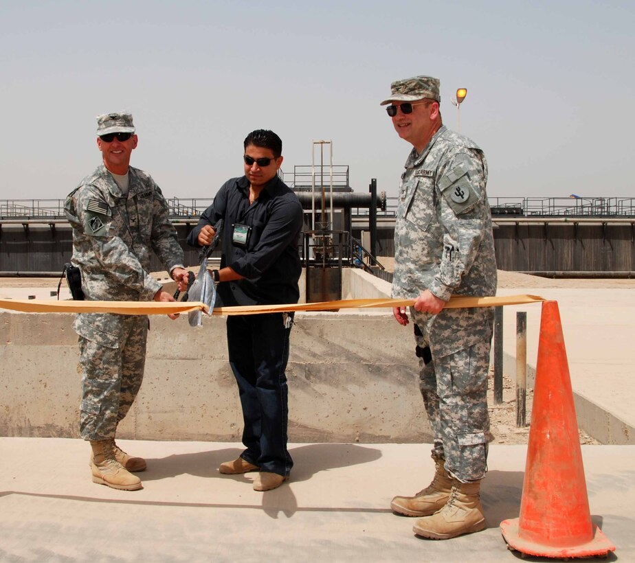 CAMP VICTORY, IRAQ – (center) U.S. Marine 2nd Lt. Ahmed Khalil, then the operations manager for Al-Andalus Company, participates in a ribbon cutting ceremony for successfully completing "Victory Base Complex Waste water treatment plant located in Camp Victory, Iraq 2007. The project added 2 million gallons of treated water to the effluent available to farmlands and inhabitants living near the canal. Khalil used his lingual skills and business acumen to work with the US military to accomplish numerous projects in Iraq.  (Courtesy photo by 2nd. Lt. Ahmed Khalil/Released)