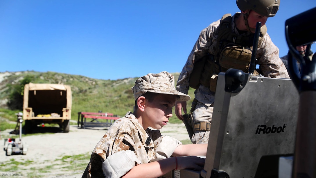 Nathan Aldaco, a 12 year-old boy with hypoplastic left heart syndrome, controls a Pacbot during a Make-A-Wish event supported by 7th Engineer Support Battalion, 1st Marine Logistics Group, at Marine Corps Base Camp Pendleton, California, March 24, 2016. Marines with 7th ESB and Explosive Ordnance Disposal helped to make Nathan’s wish of training with Marines come true by demonstrating the capabilities of their EOD robots and detonating TNT, C4, dynamite and blasting caps, while the heavy equipment operators gave him the opportunity to ride the D7 dozer and the excavator, in which he dug a pit, built a berm, and broke several large tree trunks.  