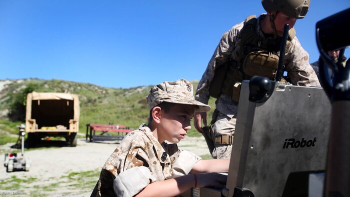 Nathan Aldaco, a 12 year-old boy with hypoplastic left heart syndrome, controls a Pacbot during a Make-A-Wish event supported by 7th Engineer Support Battalion, 1st Marine Logistics Group, at Marine Corps Base Camp Pendleton, California, March 24, 2016. Marines with 7th ESB and Explosive Ordnance Disposal helped to make Nathan’s wish of training with Marines come true by demonstrating the capabilities of their EOD robots and detonating TNT, C4, dynamite and blasting caps, while the heavy equipment operators gave him the opportunity to ride the D7 dozer and the excavator, in which he dug a pit, built a berm, and broke several large tree trunks.  