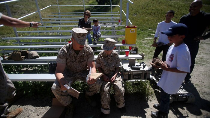 Nathan Aldaco, a 12 year-old boy with hypoplastic left heart syndrome, prepares to eat field rations with 1st Lt. Ernest Gaudio during a Make-A-Wish event supported by 7th Engineer Support Battalion, 1st Marine Logistics Group, at Marine Corps Base Camp Pendleton, California, March 24, 2016. Gaudio is a platoon commander with Bravo Company, 7th ESB, 1st MLG. Marines with 7th ESB and Explosive Ordnance Disposal helped to make Nathan’s wish of training with Marines come true by demonstrating the capabilities of their EOD robots and detonating TNT, C4, dynamite and blasting caps, while the heavy equipment operators gave him the opportunity to ride the D7 dozer and the excavator, in which he dug a pit, built a berm, and broke several large tree trunks.  