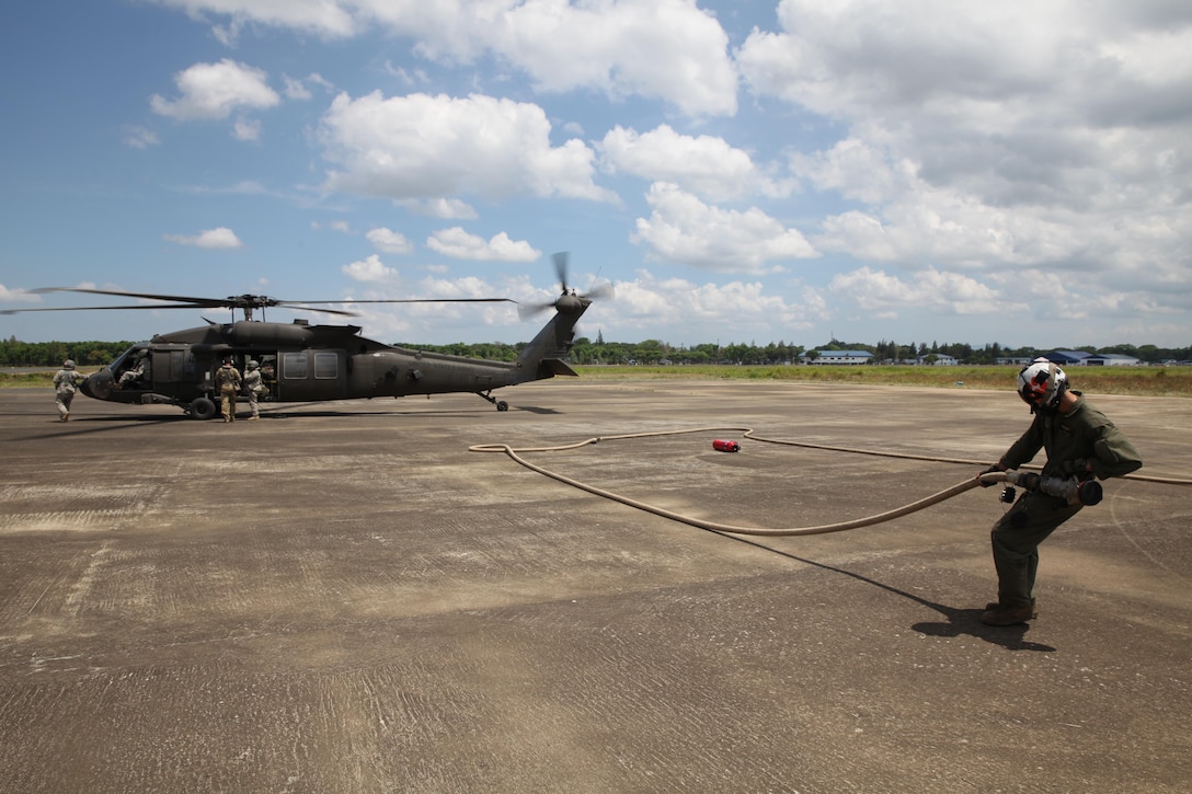 U.S. Marine Cpl. Christos Onoufriadis pulls a fuel line away from a U.S. Army UH-60 Black Hawk at an aerial delivery ground refueling station during Balikatan 16, in San Fernando, Philippines, April 12, 2016. Onoufriadis is from Redding, California and a MV-22B Osprey crew chief for Marine Medium Tilt-rotor Squadron 262, Marine Aircraft Group 36, 1st Marine Aircraft Wing, III Marine Expeditionary Force. After establishing the ADGR, the Marines of VMM-262 refueled multiple U.S. Army aircrafts from Bravo 3-25, Aviation Regiment via the MV-22B Osprey.