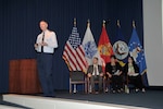 DLA Director Air Force Lt. Gen. Andy Busch delivers his opening remarks to employees at the Process Excellence All-Hands Town Hall April 12. Seated left to right: Marcus Bowers, Billie Sue Goff and Heather Vickers.