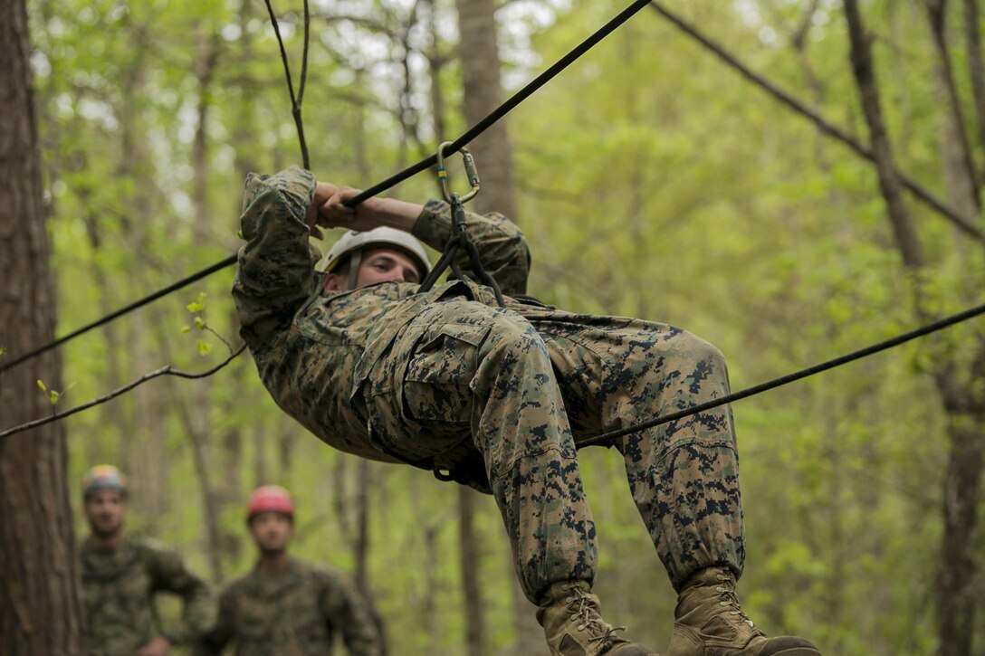 Sgt. Chris Ginandt, an instructor for the Assault Climbers Course, slides down a one-rope bridge to demonstrate the capabilities and the method of descent to the students of the course at Camp Lejeune, N.C., April 12, 2016. These bridges allow Marines from the 22nd Marine Expeditionary Unit to conduct cliff assaults, and move supplies and themselves safely across a river or cavern.