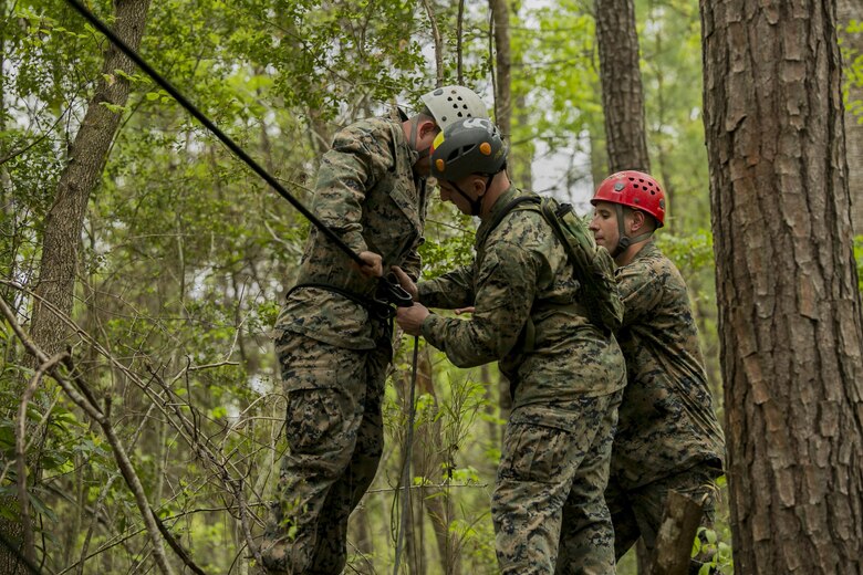 Instructors of the Assault Climbers Course detach Sgt. Chris Ginandt, an instructor for the course, from the one-rope bridge after completing his descent from the top of the cliff face at Camp Lejeune, N.C., April 12, 2016. These bridges allow Marines from the 22nd Marine Expeditionary Unit to conduct cliff assaults, and move supplies and themselves safely across a river or cavern.