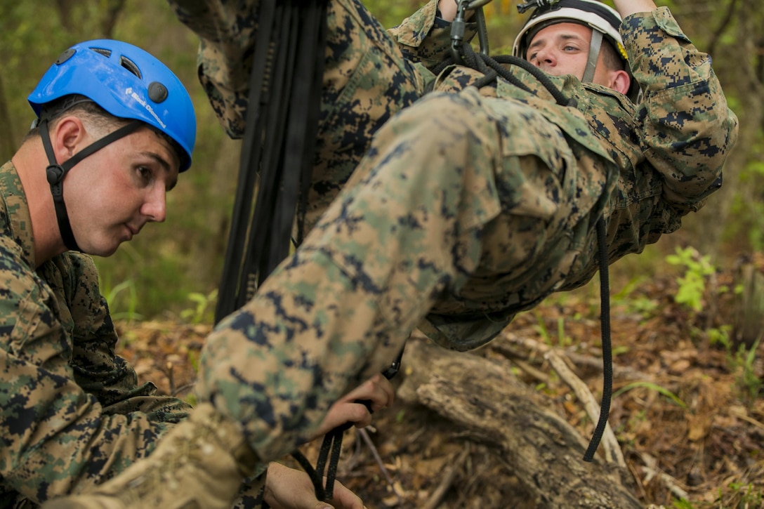 Sgt. Joshua Jelinek, the lead instructor for the Assault Climbers Course (left), attaches Sgt. Chris Ginandt, a fellow instructor, to a suspension bridge during a period of instruction at Camp Lejeune, N.C., April 12, 2016. These bridges allow Marines from the 22nd Marine Expeditionary Unit to conduct cliff assaults, and move supplies and themselves safely across a river or cavern.