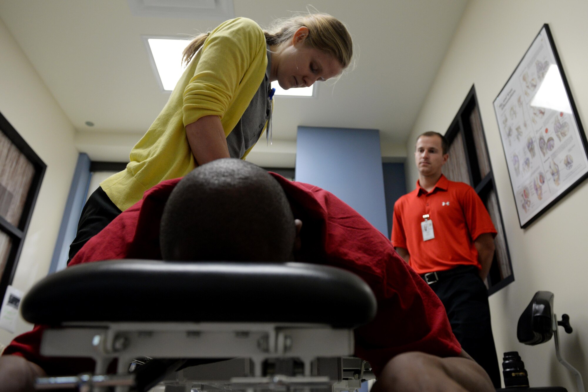 Jennifer Divis, Rocky Mountain University physical therapy intern, applies pressure to the lower back of Master Sgt. Edmon James, 335th Training Squadron instructor supervisor, in the physical therapy department April 7, 2016, Keesler Air Force Base, Miss. Applying pressure helps reduce the pain James experiences by increasing the flexibility of his lower back. (Air Force Photo by Airman 1st Class Travis Beihl)