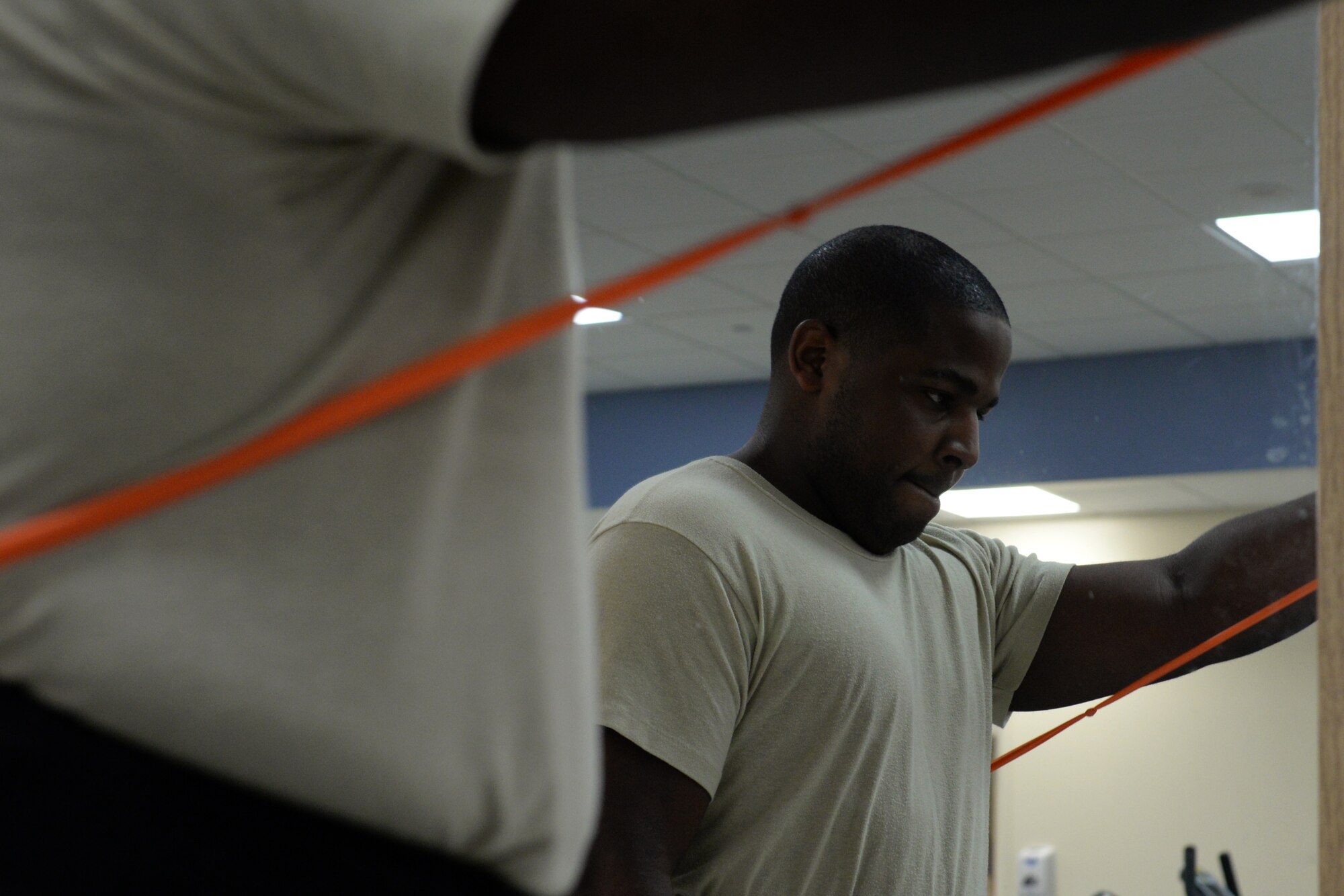 Tech. Sgt. Link Collier, 334th Training Squadron airfield management instructor supervisor, executes a front raise in the physical therapy department, April 6, 2016, Keesler Air Force Base, Miss. Performing a front (anterior) raise with a resistance band helps build strength in Collier’s injured shoulder. The exercise is performed on both sides in order to maintain balance. (Air Force Photo by Airman 1st Class Travis Beihl)