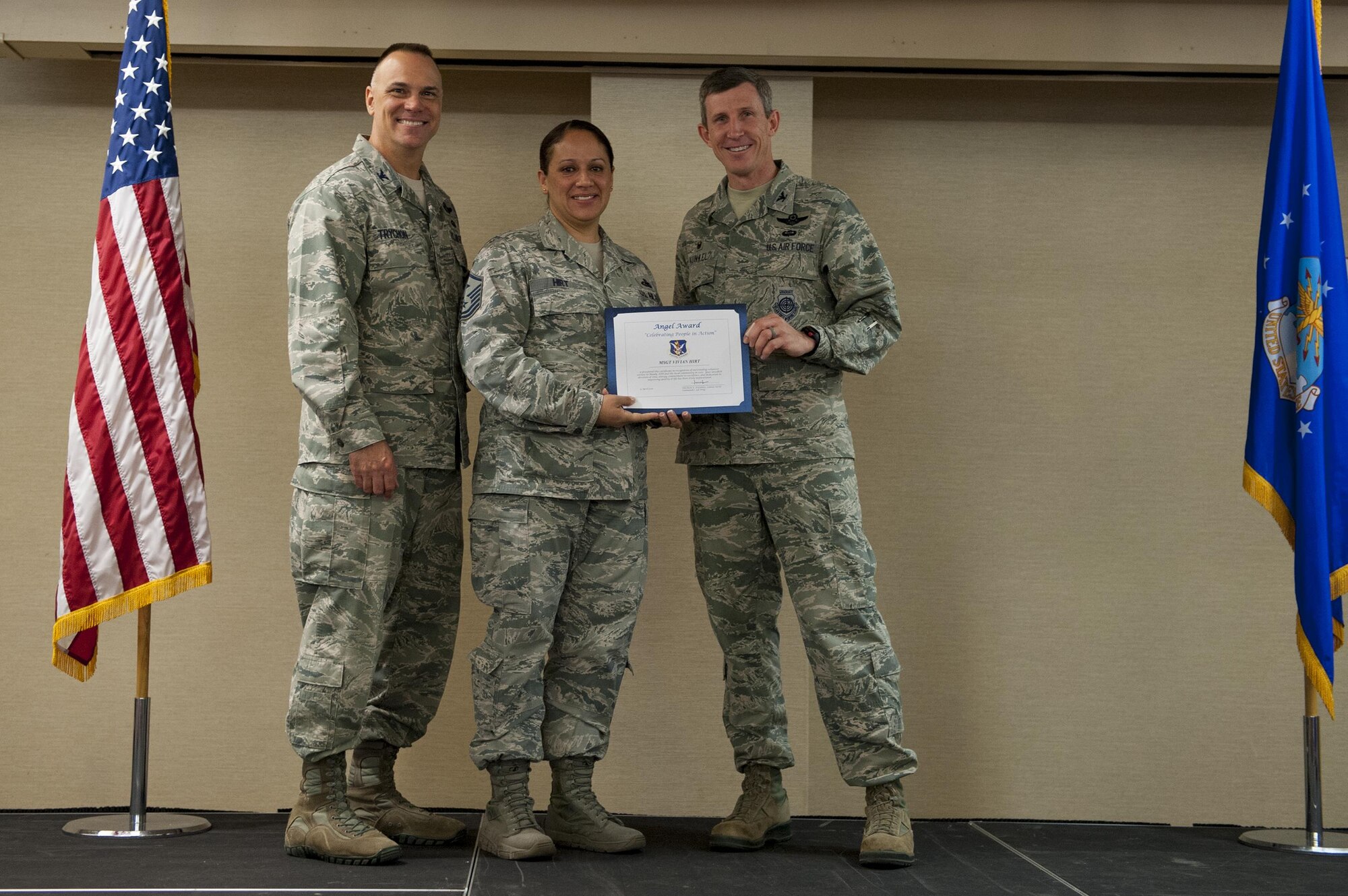 U.S. Air Force Master Sgt. Vivian Hirt, 23d Equipment Maintenance Squadron first sergeant, receives the Angel Award from Col. Thomas Kunkel, right, 23d Wing commander, and Col. Eric Trychon, left, 93d Air Ground Operations Wing vice commander, during a volunteer recognition ceremony, April 13, 2016, at Moody Air Force Base, Ga. The Angel Award recognizes volunteers who significantly enrich the quality of life on military installations. (U.S. Air Force photo by Airman 1st Class Lauren M. Hunter/Released)