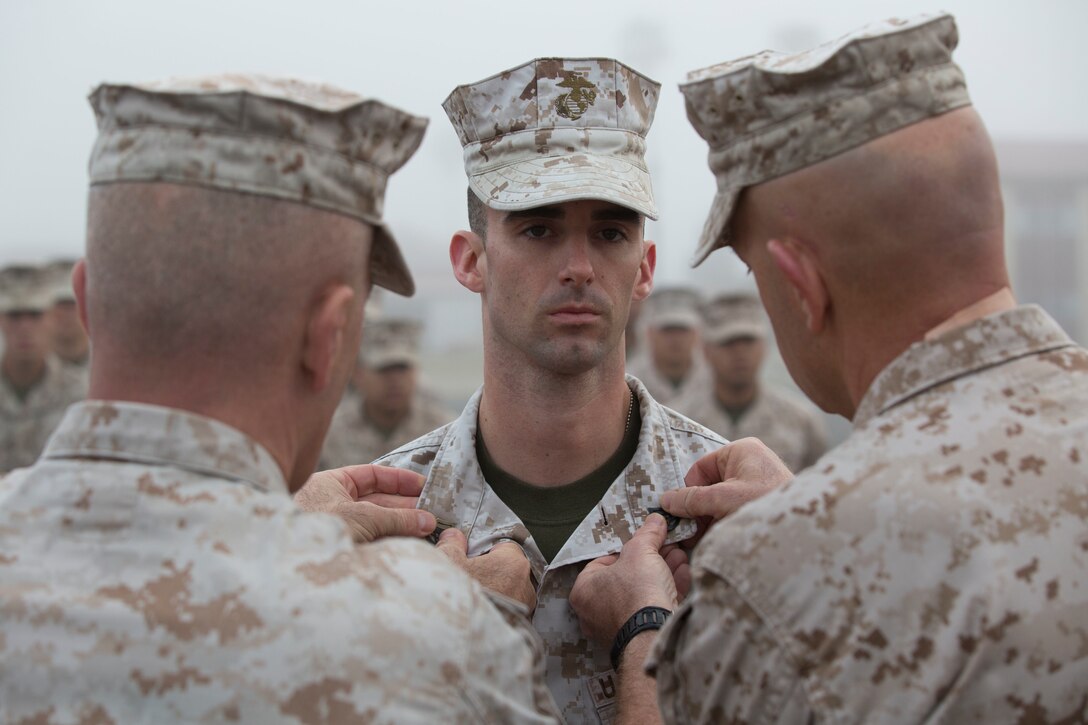 MARINE CORPS BASE CAMP PENDLETON, Calif. – Lieutenant General David Berger, I Marine Expeditionary Force commanding general, and Sgt. Maj. Bradley Kasal, I MEF Sergeant Major, meritoriously promote SSgt. Kurtis Carpenter, an armorer with 1st Intelligence Battalion, and Louisa, VA., April 4, 2016. Meritorious promotions are a way for the Marine Corps to reward outstanding performance and highlight the dedication and spirit among those who serve within it. (Marine Corps photo by Cpl. Jonathan Boynes/Released)