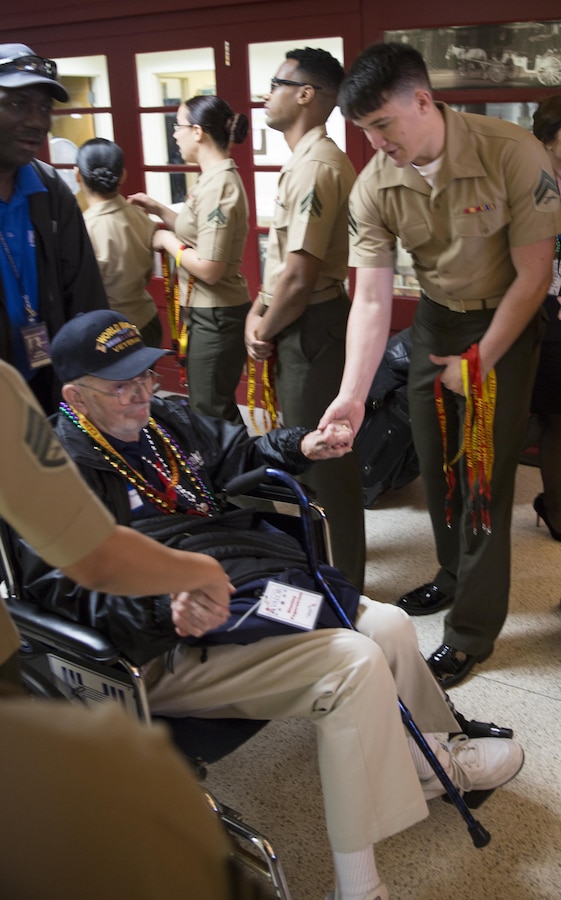 Cpl. William C. Parker (right), a data network specialist with Marine Forces Reserve G-6, shakes hands with Stanley Fagerstrom (left), an Army World War II veteran, as he exits Louis Armstrong New Orleans International Airport, April 13, 2016.  Fagerstrom joined other World II veterans as part of Soaring Valor, a program created by the Gary Sinise foundation to provide World War II veterans a special tour of the National World War II Museum and to honor them for their sacrifices. (U.S. Marine Corps photo by Cpl. Ian Leones/ Released)