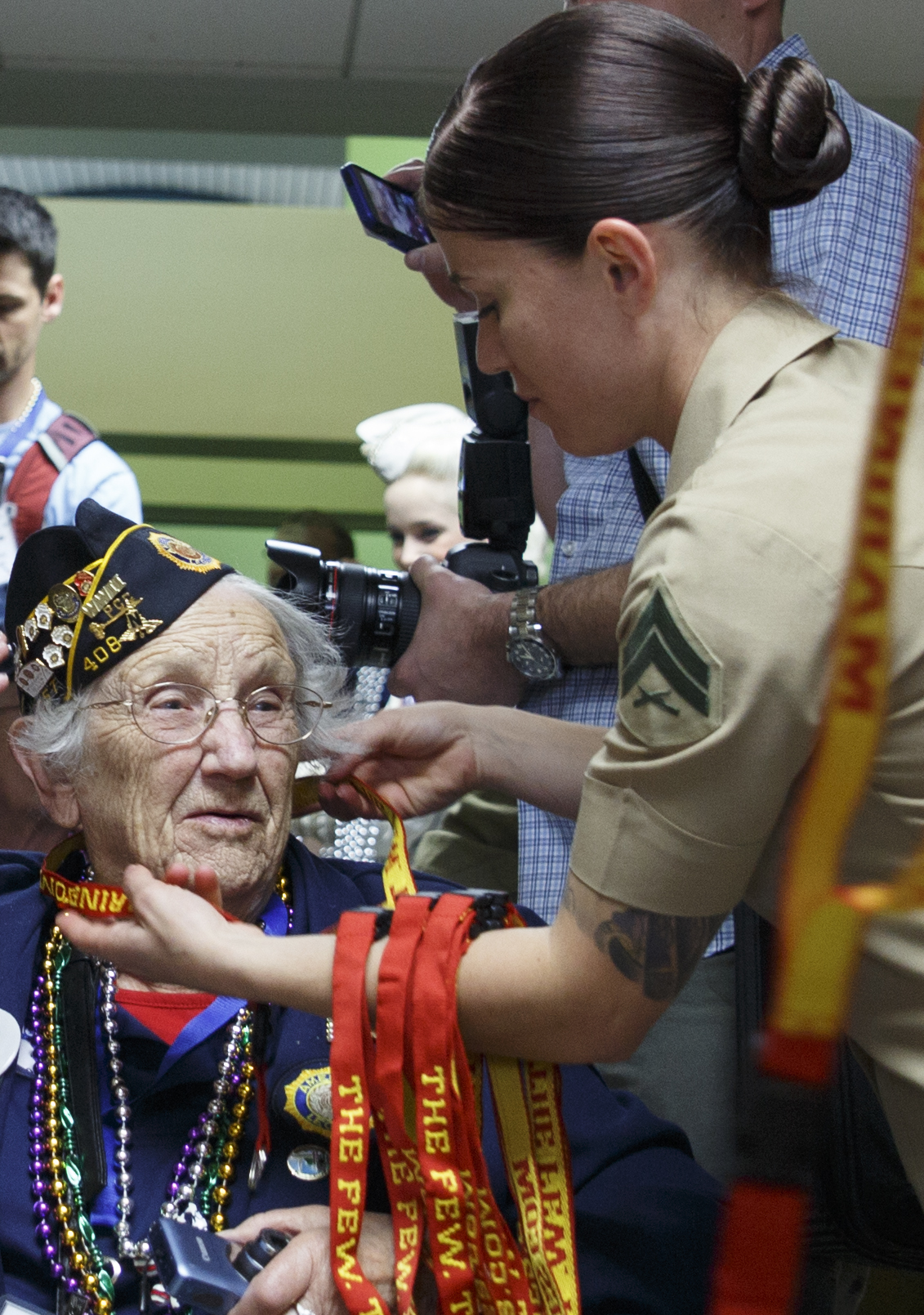 Cpl. Emanuela S. Shehu (right), an administrative specialist with Headquarters Battalion, Marine Forces Reserve, places a Marine Corps lanyard around the neck of Lou Lieske (left), a retired U.S. Army nurse and World War II veteran, at Louis Armstrong New Orleans International Airport, April 13, 2016. Lieske joined other World II veterans as part of Soaring Valor, a program created by the Gary Sinise foundation to provide World War II veterans a special tour of the National World War II Museum and to honor them for their sacrifices. (U.S. Marine Corps photo by Cpl. Ian Leones/ Released)