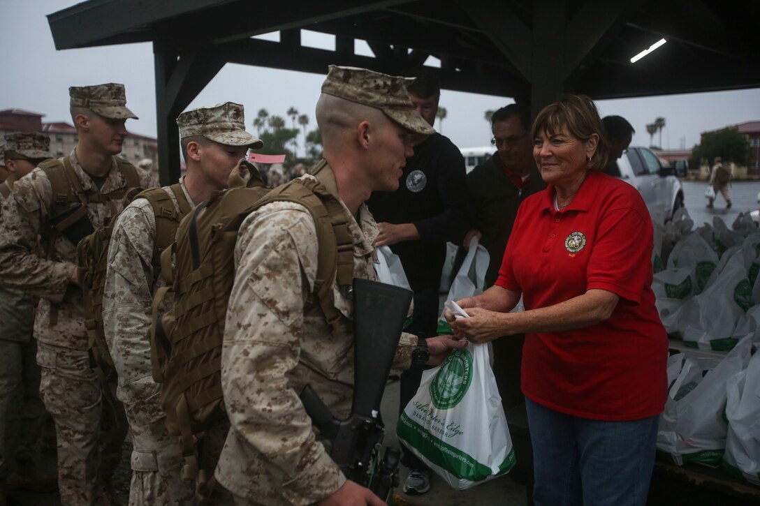 MARINE CORPS BASE CAMP PENDLETON, Calif. – Jill Martin, a volunteer with the Dana Point 5th Marine Regiment Support Group of San Clemente, hands out gift bags to Marines and sailors with Special Purpose Marine Air-Ground Task Force - Crisis Response - Central Command 16.2 April 8, 2016, at Camp Pendleton. Marines with SPMAGTF-CR-CC make up a rotational contingent of approximately 2,300 Marines, sailors and support elements sourced from units throughout I Marine Expeditionary Force. In its fourth iteration, the unit serves as the Marine Corps’ land-based, expeditionary crisis and contingency force in U.S. Central Command. (U.S. Marine Corps photo by Cpl. Angel Serna/Released)