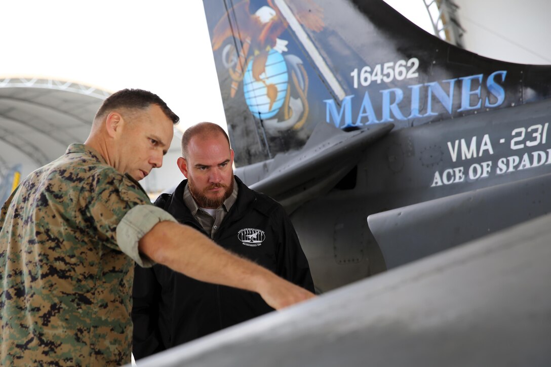 Col. Eric Austin, left, points at the wing of an AV-8B Harrier with Havelock Mayor William Lewis during a tour of the flight line at Marine Corps Air Station Cherry Point, N.C., April 6, 2016 According to Lewis, the tour was part of his efforts to strengthen the already well-established relationship between the Havelock and Cherry Point communities. He looks to grow community ties with the air station by understanding the mission of the 2nd Marine Aircraft Wing and its squadrons, said Lewis. Austin is the commanding officer of Marine Aircraft Group 14. (U.S. Marine Corps photo by Lance Cpl. Mackenzie Gibson/Released.)