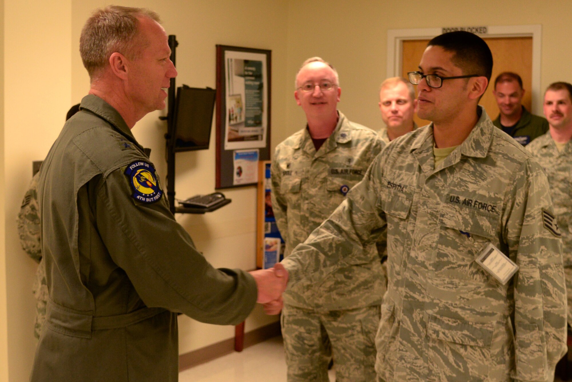 Maj. Gen. Mark Kelly, 9th Air Force commander coins Staff Sgt. David Espitia, 4th Medical Operations Squadron family health technician, April 8, 2016, at Seymour Johnson Air Force Base, North Carolina. During his visit, Kelly recognized superior performers from several squadrons on base and spoke about each of their impacts on the mission of the 4th Fighter Wing and 9th AF. (U.S. Air Force photo/Staff Sgt. Chuck Broadway)