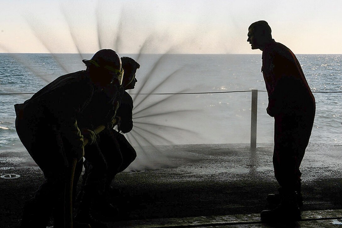 Sailors practice using a fire hose during a damage control rodeo aboard the USS Bataan in the Atlantic Ocean, April 10, 2016. The Bataan is conducting routine qualifications in preparation for future deployments. Navy photo by Seaman Apprentice Zachariah Grabill