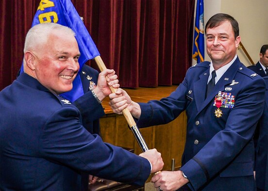Col. Scott Snyder (right) relinquishes command of the 446th Operations Group here, to Col. Scott McLaughlin, 446th Airlift Wing commander here, during the group's change of command ceremony April 2, 2016. (U.S. Air Force Reserve photo by Staff Sgt. Daniel Liddicoet)