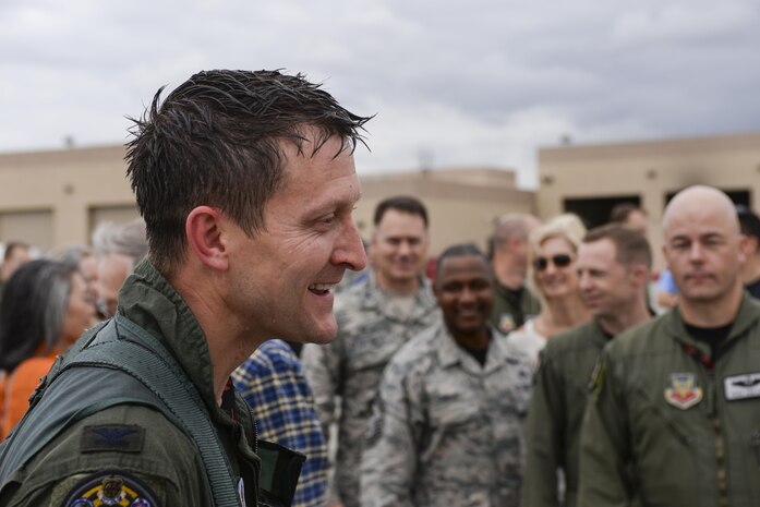 Col. Aaron Steffens, 57th Wing vice commander, greets family and friends after being showered with champagne and water after his fini flight at Nellis Air Force Base, Nev., April 8, 2016. The 57th Wing Group provides advanced aerospace training to world-wide combat air forces and showcases aerospace power to the world while overseeing the dynamic and challenging flying operations at Nellis. (U.S. Air Force photo by Airman 1st Class Nathan Byrnes)