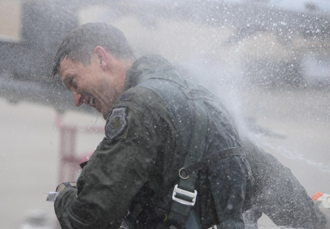 Col. Aaron Steffens, 57th Wing vice commander, is showered with champagne and water as he exits his aircraft after his fini flight at Nellis Air Force Base, Nev., April 8, 2016. As vice commander of the 57th Wing, Steffens was instrumental in managing all flying operations at Nellis AFB and conducts advanced aircrew, space, logistics and command and control training through the USAF Weapons School, Red Flag and Green Flag exercises. (U.S. Air Force photo by Airman 1st Class Nathan Byrnes)