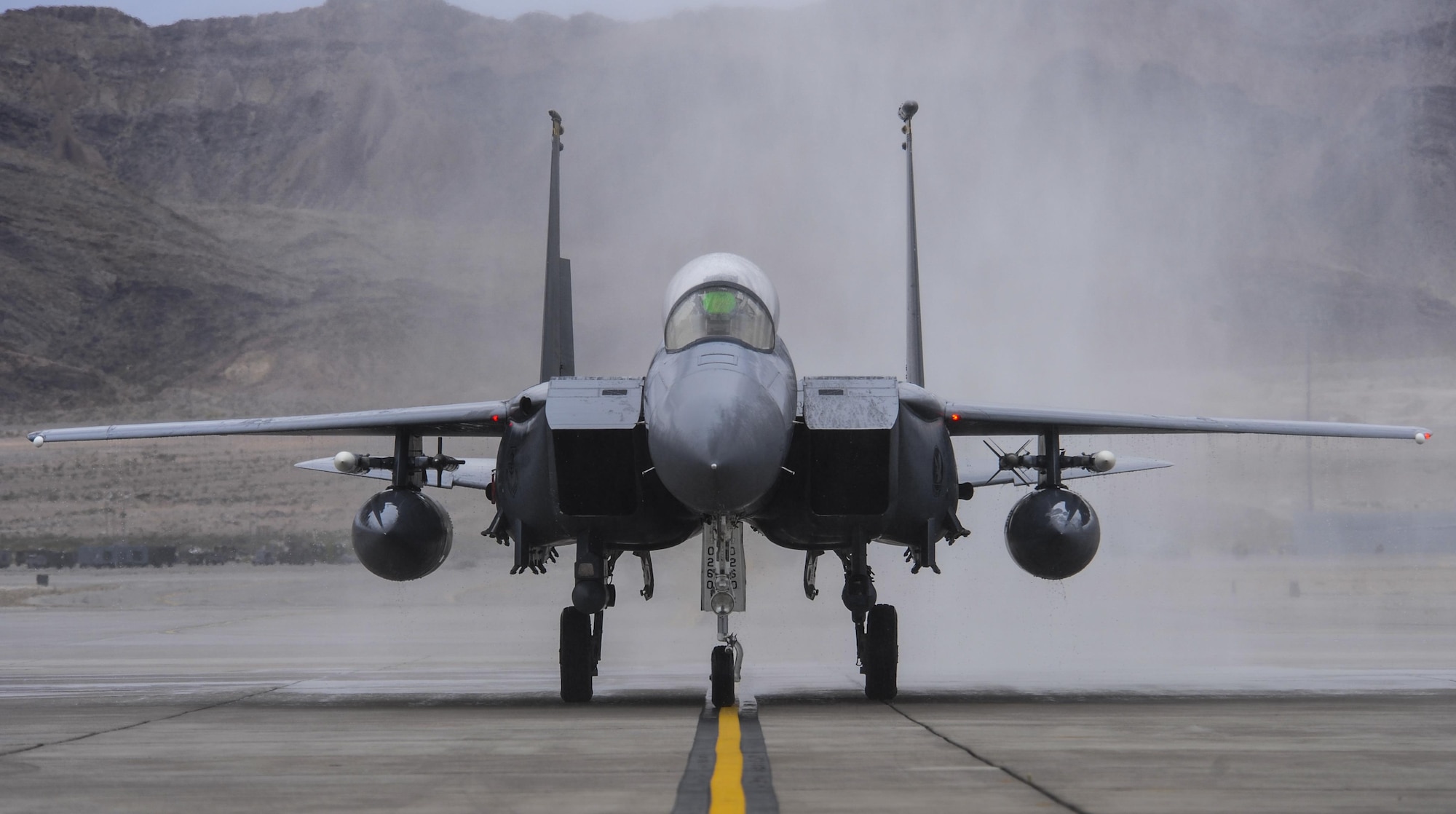 Brig. Gen. Christopher Short, 57th Wing commander, taxis down the runway in an F-16 Fighting Falcon after being sprayed by fire trucks during his fini flight at Nellis Air Force Base, Nev., April 8, 2016. A fini flight is a pilot’s last flight in an aircraft before he/she leaves a squadron, a wing, or retires from the Air Force. (U.S. Air Force photo by Airman 1st Class Kevin Tanenbaum)