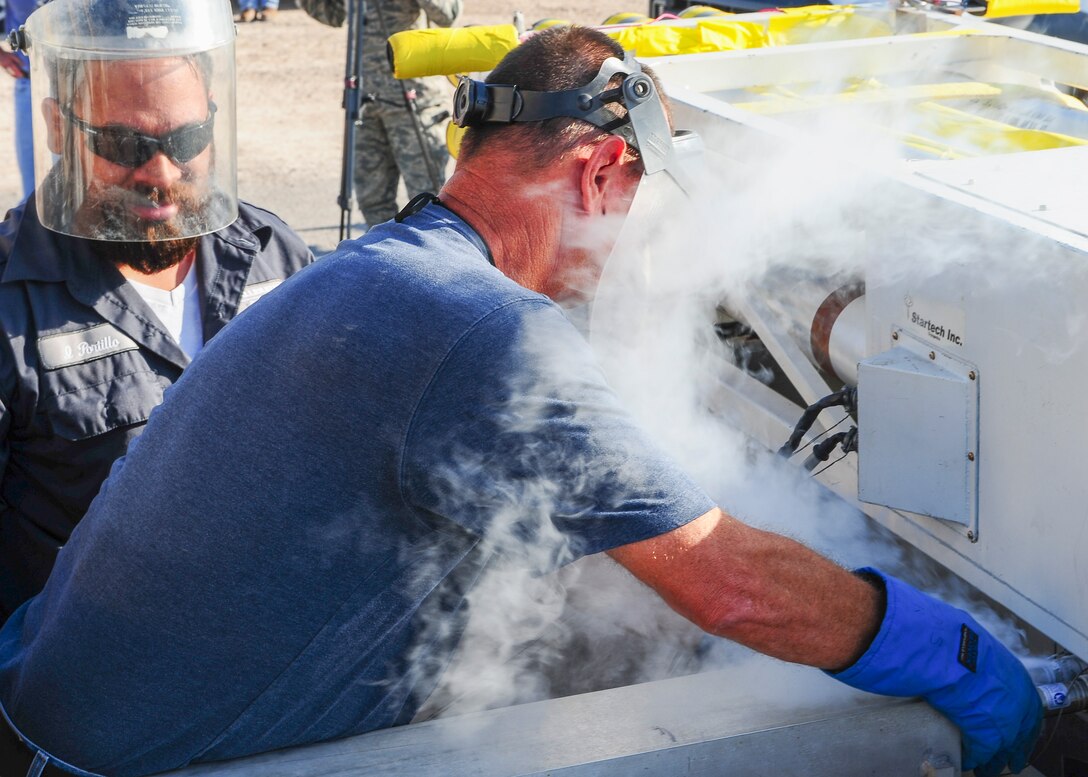 Technicians from the 846th Test Squadron at Holloman Air Force Base, N.M., pump liquid helium into a test sled here Aug. 18, 2015. This sled system runs on four super-conducting magnets that need to be cooled down to a few degrees above absolute zero to ensure the smoothest ride possible. (U.S. Air Force photo by Airman 1st Class Randahl J. Jenson)   