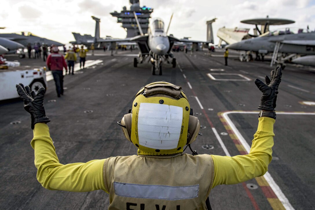 Navy Petty Officer 2nd Class Keyonnia Cook directs an F/A-18F Super Hornet on the flight deck of the USS Dwight D. Eisenhower in the Atlantic Ocean, April 6, 2016. The Eisenhower is conducting a unit training exercise with its carrier strike group. Navy photo by Petty Officer 3rd Class J. Alexander Delgado