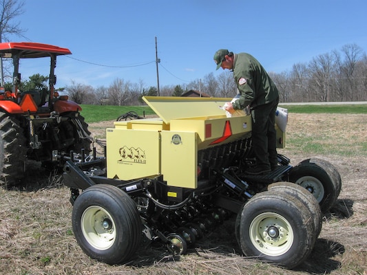 John Scheiber, Salamonie Lake Project Manager, pours prairie grass seed into the no-till drill specifically designed to plant prairie species. The drill was purchased using Handshake Partnership funding along with funding from the National Wild Turkey Federation.  