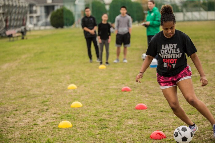 Maya Pugh, a teen from Yokosuka Naval Base, relays a soccer ball through cones during a fitness competition at the 2016 Asia Keystone Conference at Marine Corps Air Station Iwakuni, Japan, April 13, 2016. Teens from various Boys and Girls Clubs across Asia participated in events like this and more during the 2016 Asia Keystone Conference. (U.S. Marine Corps photo by Cpl. Nathan Wicks/Released)
